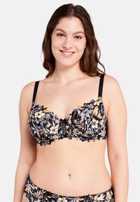Sujetador balconette de encaje floral en negro con patrones de flores multicolores, bordes rizados y tirantes ajustables. Se pueden ver las braguitas a juego.