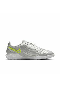 Light gray sneaker featuring mesh and synthetic materials, with a curved design and neon yellow accents. Rubber sole with textured patterns.