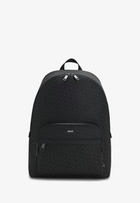 Mochila de tela negra con un acabado mate, forma redondeada y detalle de logo. Cuenta con un bolsillo frontal con cremallera y dos cierres en la parte superior con cremallera.