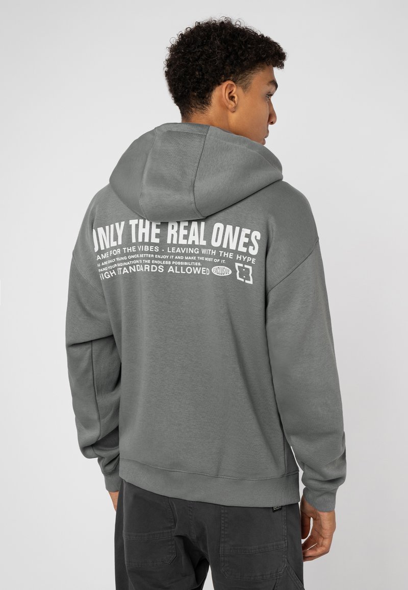 Gray hoodie made of cotton blend, featuring a spacious hood and large white text graphic on back. Ribbed cuffs and hem complete the design.