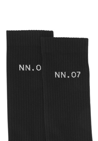 Calze nere a coste con testo bianco "NN.07". Materiale morbido con altezza a metà polpaccio e un design semplice e minimalista.