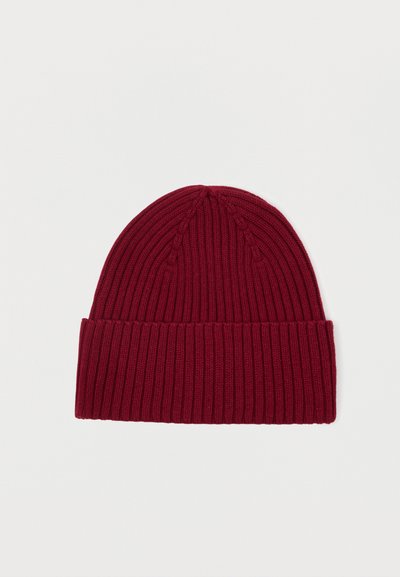 Πλεκτό σκουφάκι σε μπορντό, με ραβδωτή υφή και διπλωμένο χείλος. Η κορυφή είναι στρογγυλή με διακριτές ραφές.