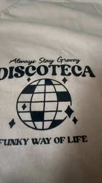 Kanga peal on kiri "Always Stay Groovy DISCOTECA" diskokera graafika kohal, all mustades tähtedes "Funky Way of Life".