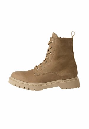 Stivaletti alla caviglia in suede tan con punta rotonda, lacci frontali e linguetta. Presentano una suola spessa e texturizzata e cuciture a vista.
