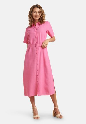 Roze knoopjurk met korte mouwen, een ceintuur in de taille en zijsplitten, gemaakt van lichte stof met een gladde textuur.