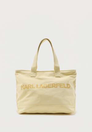 Bézs színű vászontáskakét fogóval, rajta elöl a "KARL LAGERFELD" feliratbézsszínű betűkkel.