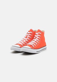 Hochschuhe aus leuchtend orangefarbenem Canvas mit weißen Schnürsenkeln, Gummi-Zehenkappe und schwarzem Seitenstreifen. Strukturierte Oberseite und gepolsterter Kragen.