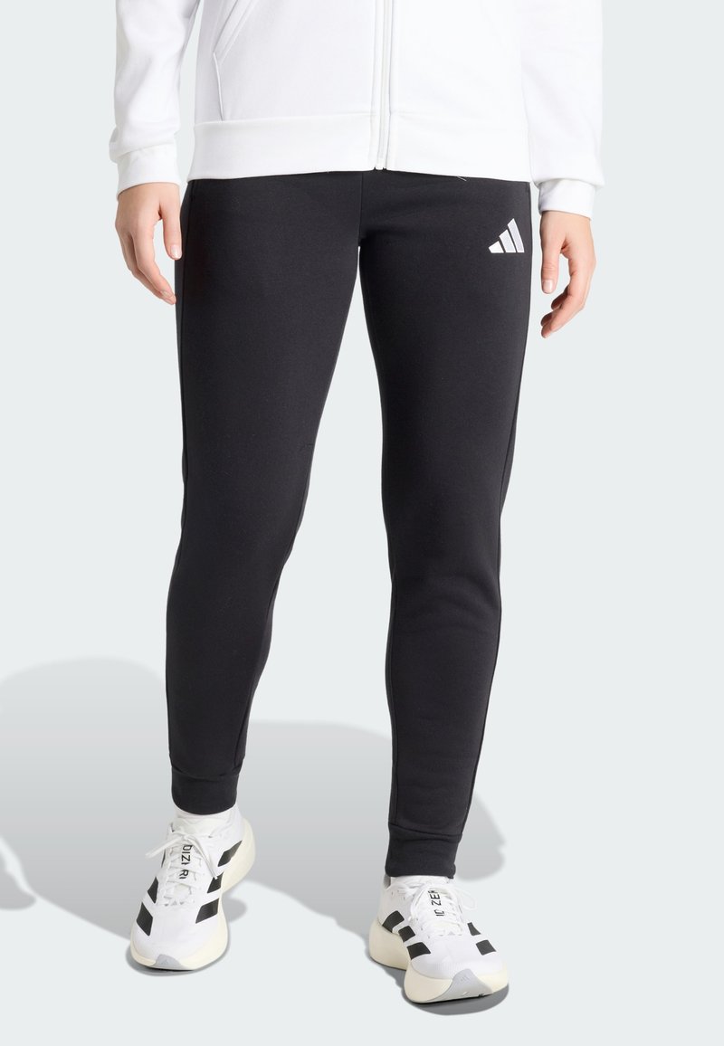 Leggings de sport noirs avec une coupe ajustée, fabriqués dans un tissu lisse. Présentent un logo Adidas blanc sur la cuisse gauche.