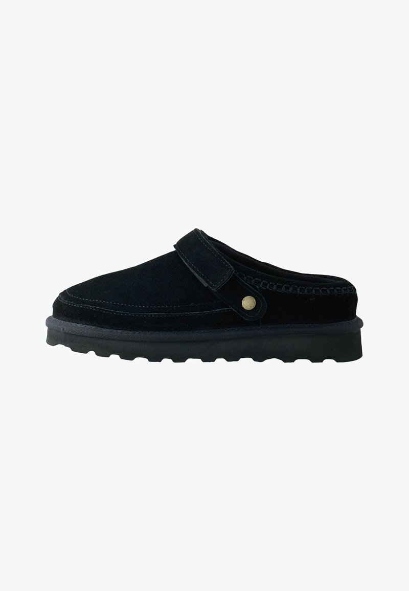 Scarpa slip-on in suede nero con punta rinforzata, cinturino laterale e suola in gomma testurizzata con tacchetti per una migliore aderenza.