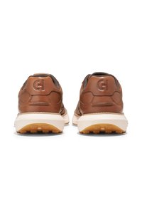 Bruna lädersneakers med vadderade mörkgrå detaljer, texturerade sulor och präglad logotyp på hälen. Vadderad, rundad design för komfort.