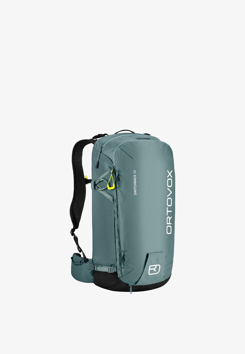 Ortovox Switchback 32 Rucksack in Türkis, mit einem eleganten Design, strukturiertem Stoff, verstellbaren Trägern und leuchtend gelben Akzentdetails.