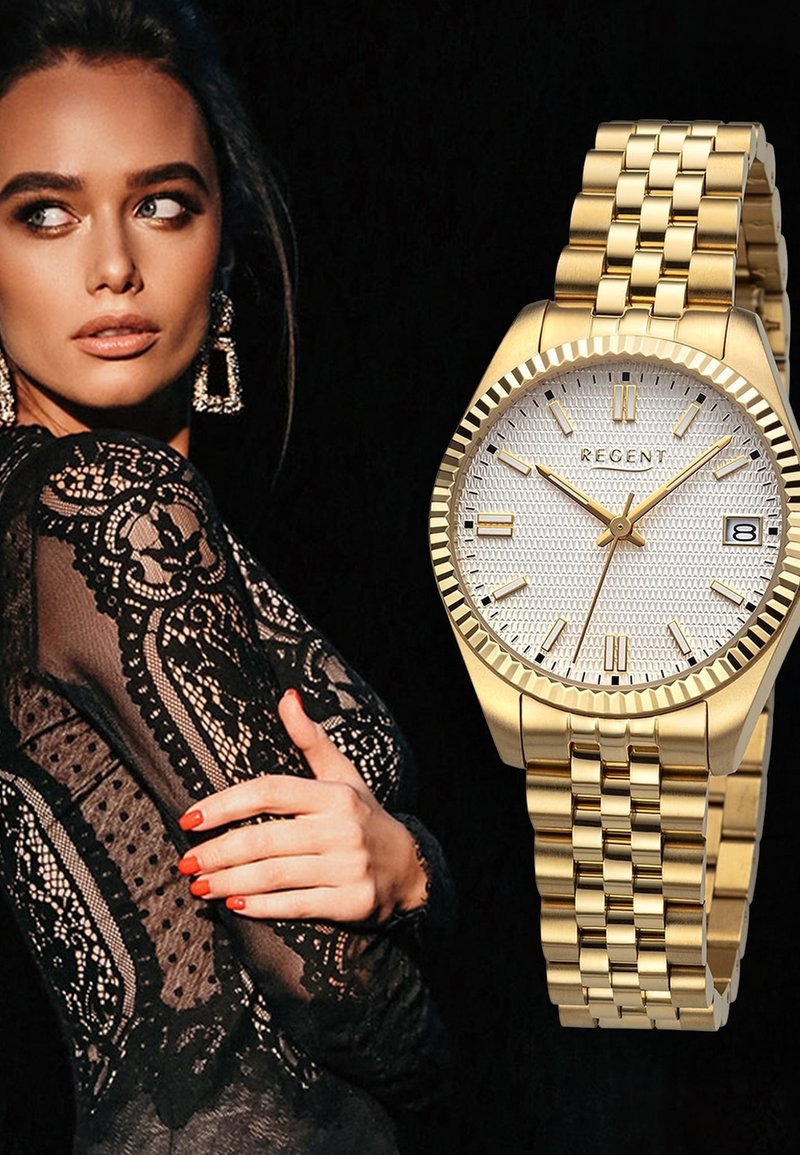 Montre en or avec un bracelet en métal poli, un cadran argenté texturé et des index horaires en or. Dispose d'un guichet de date à 3 heures.