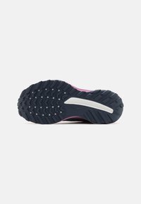 La semelle de la chaussure de course présente un robuste contour en caoutchouc noir, un intersole rose et un accent blanc. Texturée pour une meilleure adhérence et stabilité.