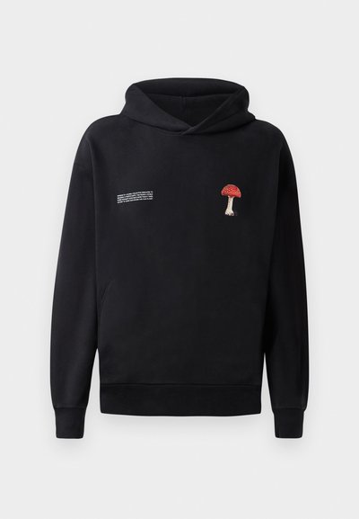 Felpa nera con cappuccio e tasca a marsupio sul fronte, caratterizzata da un ricamo di un fungo rosso e bianco sul petto e testo bianco sul lato.