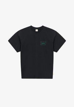 Camiseta negra de manga corta con cuello redondo y pequeño logo rectangular verde en el área del pecho izquierdo.