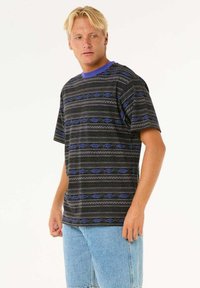 Kortærmet t-shirt i sort med blå geometriske mønstre, rund halsudskæring, afslappet pasform, lavet af blødt stof, parret med lyse denimshorts.