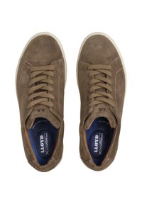 Sneaker in suede marrone con una texture liscia, dotate di una suola in gomma bianca e una fodera interna blu scuro a contrasto. I lacci sono dello stesso colore delle scarpe.