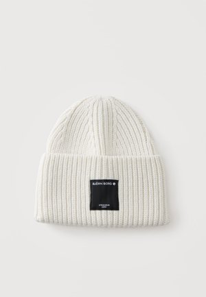 Bonnet tricoté côtelé blanc avec revers et étiquette rectangulaire noire portant l'inscription Björn Borg Stockholm 1956 au centre devant.