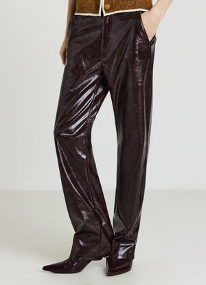 Pantaloni in pelle lucida color bordeaux scuro con vestibilità ampia. Caratteristiche notevoli includono tasche laterali e una texture liscia e lucida.