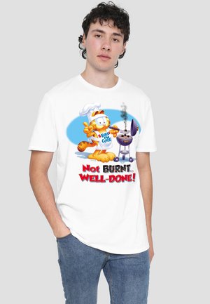 White cotton t-shirt featuring a colorful illustrated cat with a chef hat next to a grill, text reads "Not BURNT... WELL-DONE!" in bold red letters.