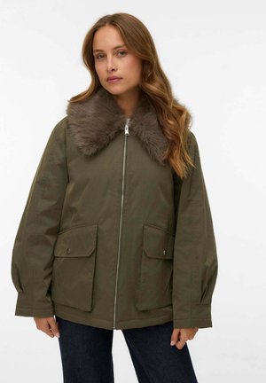 Giacca verde oliva con collo in pelliccia sintetica, chiusura con zip e due tasche anteriori con pattina. Presenta una vestibilità ampia e maniche lunghe con polsini.