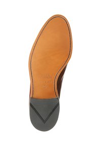 Braune Ledersohle mit strukturiertem schwarzen Gummifersen, versehen mit eingeprägtem Markenlogo und eleganter Naht entlang des Randes.
