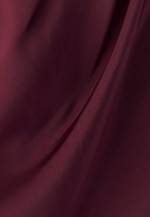 Burgundy-kangas, jossa on sileä, satiininen rakenne, pehmeät laskokset ja taitteet, jotka vangitsevat valoa ja antavat hieman kiiltävän ilmeen.