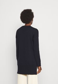 Marineblaues langärmliges Sweatshirt mit gerippten Bündchen und Saum, ausgestattet mit einem Rundhalsausschnitt und einem Oversize-Schnitt, aus einem weichen Strickmaterial gefertigt.