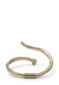 Brazalete abierto de metal dorado con una forma ligeramente torcida e irregular y un detalle de espiral cerca de la apertura.