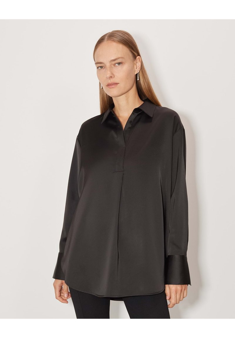 Blusa nera in satin con colletto a punta e maniche lunghe, caratterizzata da un taglio dritto e un leggero lucido. Design elegante con una texture morbida.