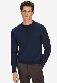 Marineblauwe wollen trui met een geribbelde ronde hals, lange mouwen en een aansluitende tailleband; soepele textuur met minimale ontwerpdetails.