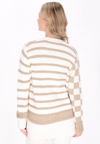 Cardigan a righe beige e bianche con una vestibilità lunga e rilassata, orlo a coste e lavorazione a maglia testurizzata. Presenta righe orizzontali senza motivi.