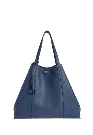 Sac cabas en cuir bleu marine avec double bandoulière, un détail pompon et une petite étiquette logo rectangulaire à l'avant.