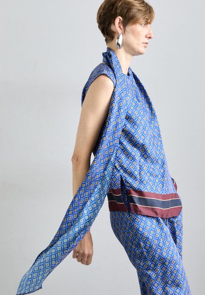 Blaue gemusterte Bekleidung mit Rautenformen, gelben Akzenten und kastanienbraunen horizontalen Streifen. Glatte Textur mit weiten Ärmeln.