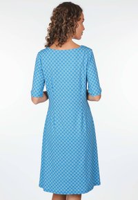 Blaues Kleid mit halben Ärmeln und einem runden Ausschnitt, das ein geometrisches Muster in unterschiedlichen Blautönen zeigt. A-Linie-Silhouette mit Taschen.