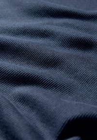 Marinblått strukturerat tyg med subtila ribbningar, som visar en slät yta och mjuk fall, perfekt för kläder eller stoppningsapplikationer.