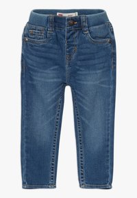 Tajta jeans i mörkblå denim med ribbat elastiskt midjeband, som har fem fickor, stikningar och stängning med framknapp.