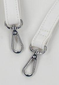 Bracelet en cuir blanc avec des fermoirs en métal argenté, présentant des détails de couture. Le bracelet est lisse et plat, avec une finition brillante sur le matériel.