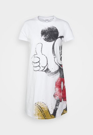 Robe t-shirt en coton blanc avec un grand motif coloré de Mickey Mouse, portant un short rouge, des chaussures jaunes et faisant un geste de pouce levé.
