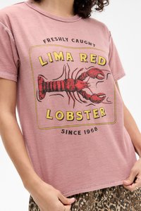 Pink cotton t-shirt featuring a lobster graphic with "LIMA RED LOBSTER" text, round neck, and short sleeves. Soft texture, relaxed fit.