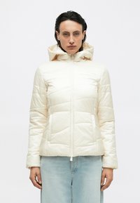 Piumino color crema, con zip frontale, cappuccio attaccato e design trapuntato. Caratterizzato da maniche lunghe e una silhouette aderente.