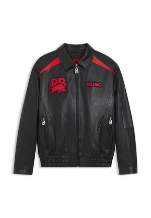 Μαύρο δερμάτινο μπουφάν με κόκκινες λεπτομέρειες, φερμουάρ μπροστά, πλευρικές τσέπες με φερμουάρ και κόκκινες επιφάνειες με τις λέξεις "RB" και ένα ταύρο, καθώς και τη λέξη "HUGO" στο στήθος.
