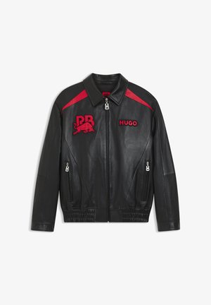 Μαύρο δερμάτινο μπουφάν με κόκκινες λεπτομέρειες, φερμουάρ μπροστά, πλευρικές τσέπες με φερμουάρ και κόκκινες επιφάνειες με τις λέξεις "RB" και ένα ταύρο, καθώς και τη λέξη "HUGO" στο στήθος.