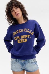 Sweatshirt púrpura com "Statesville Ath Dept. 431" em texto amarelo desbotado, combinado com calções de ganga claros. Corte descontraído e decote redondo.