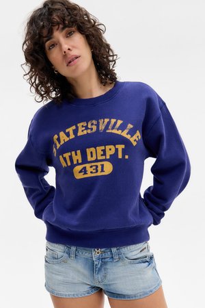 Lila kapucnis pulóver "Statesville Ath Dept. 431" elhalványult sárga felirattal, világos farmer rövidnadrággal párosítva. Lazán illeszkedő, kerek nyakkivágású.