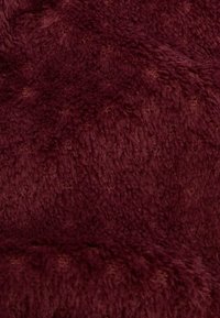 Tessuto in pelliccia sintetica color bordeaux con una consistenza morbida e soffice e un motivo sottile, caratterizzato da una superficie densa e vellutata, ideale per tappezzeria o abbigliamento.