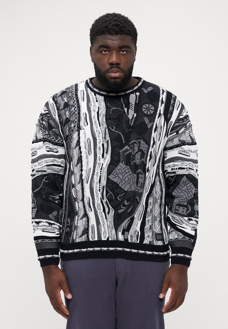 Black and white knit sweater featuring intricate patterns, textured fabric, crew neck, and ribbed cuffs. The design includes abstract elements.