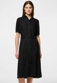 Juodas marškinėlių suknelė su trumomis rankovėmis, apykakle ir dirželiu. Pagaminta iš lengvos medžiagos, turi kišenę ir kelnių ilgio dizainą.