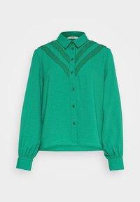 Camicia verde con chiusura a bottoni davanti, colletto classico e dettagli in pizzo testurizzato sulle spalle, con maniche lunghe e polsini arricciati.