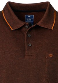 Braunes Polo-Shirt aus strukturiertem Stoff, kontrastierender orangefarbener Kragen, Knopfleiste mit drei Knöpfen und ein kleines Logo auf der Brusttasche.